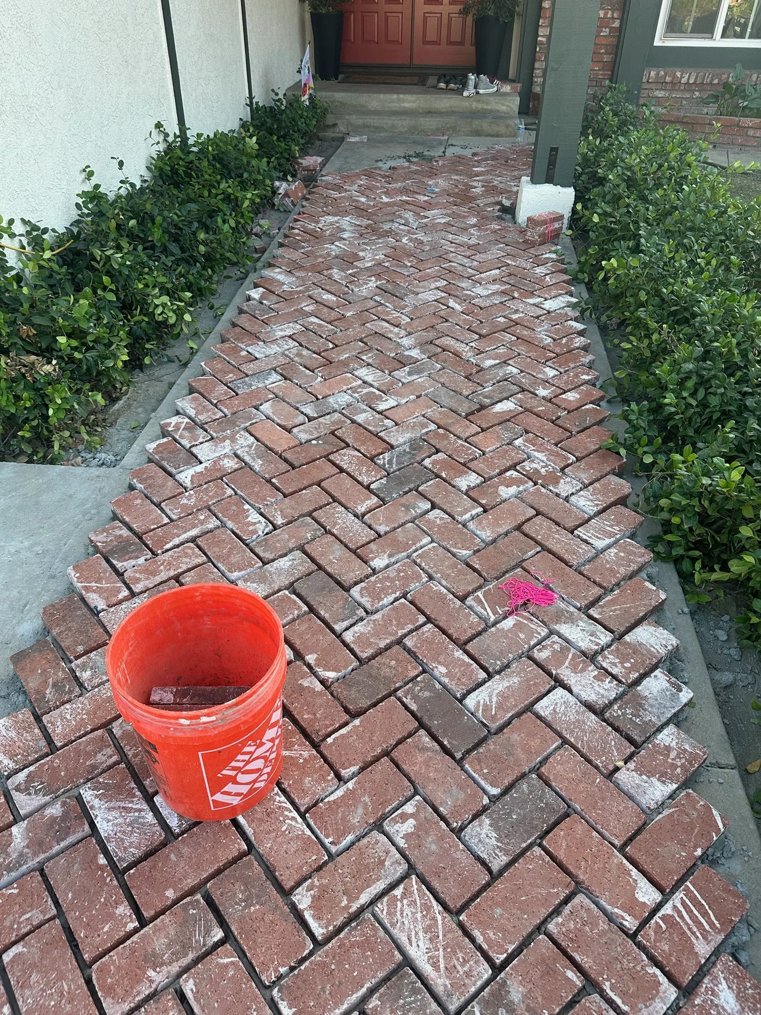 Brick walkway being laid in a herringbone pattern