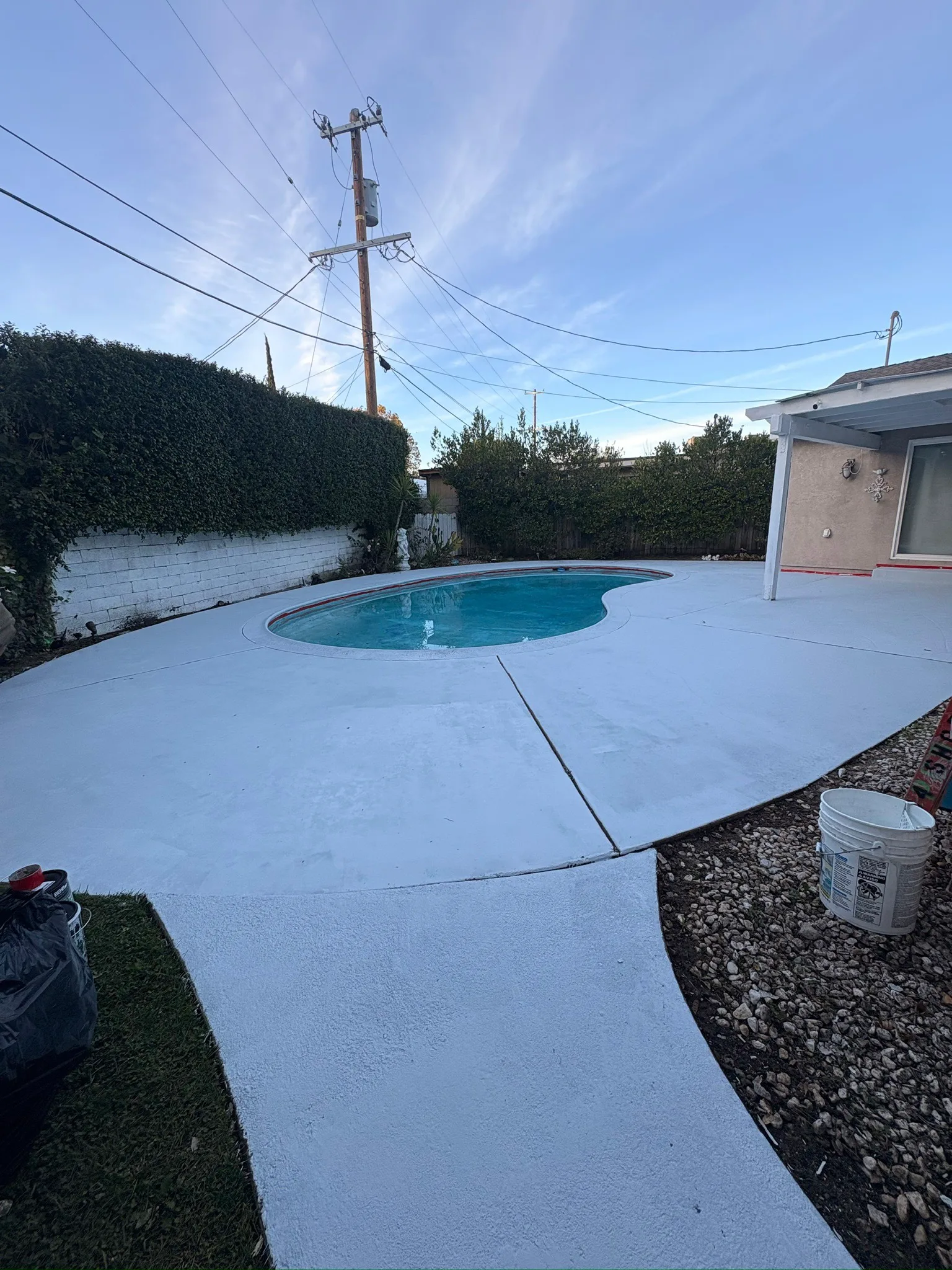 Fresh concrete pool deck around a backyard pool