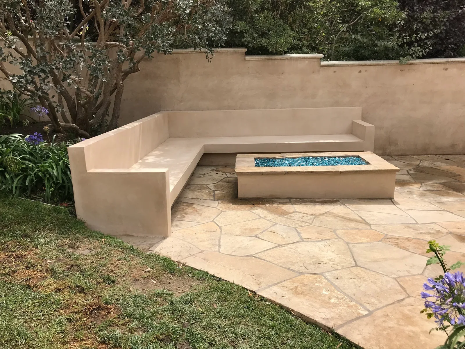Flagstone patio with fire pit and curved bench built by Camberos Masonry