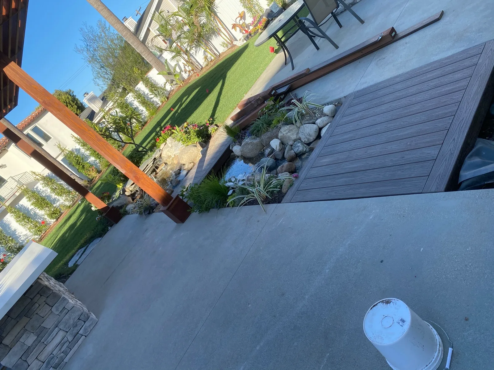 Pergola over a fresh concrete patio with stone accents