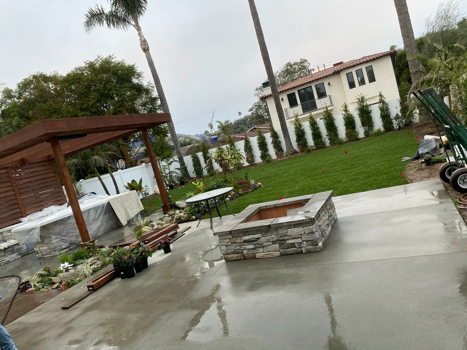 Backyard with pergola, stone fire pit and fresh turf