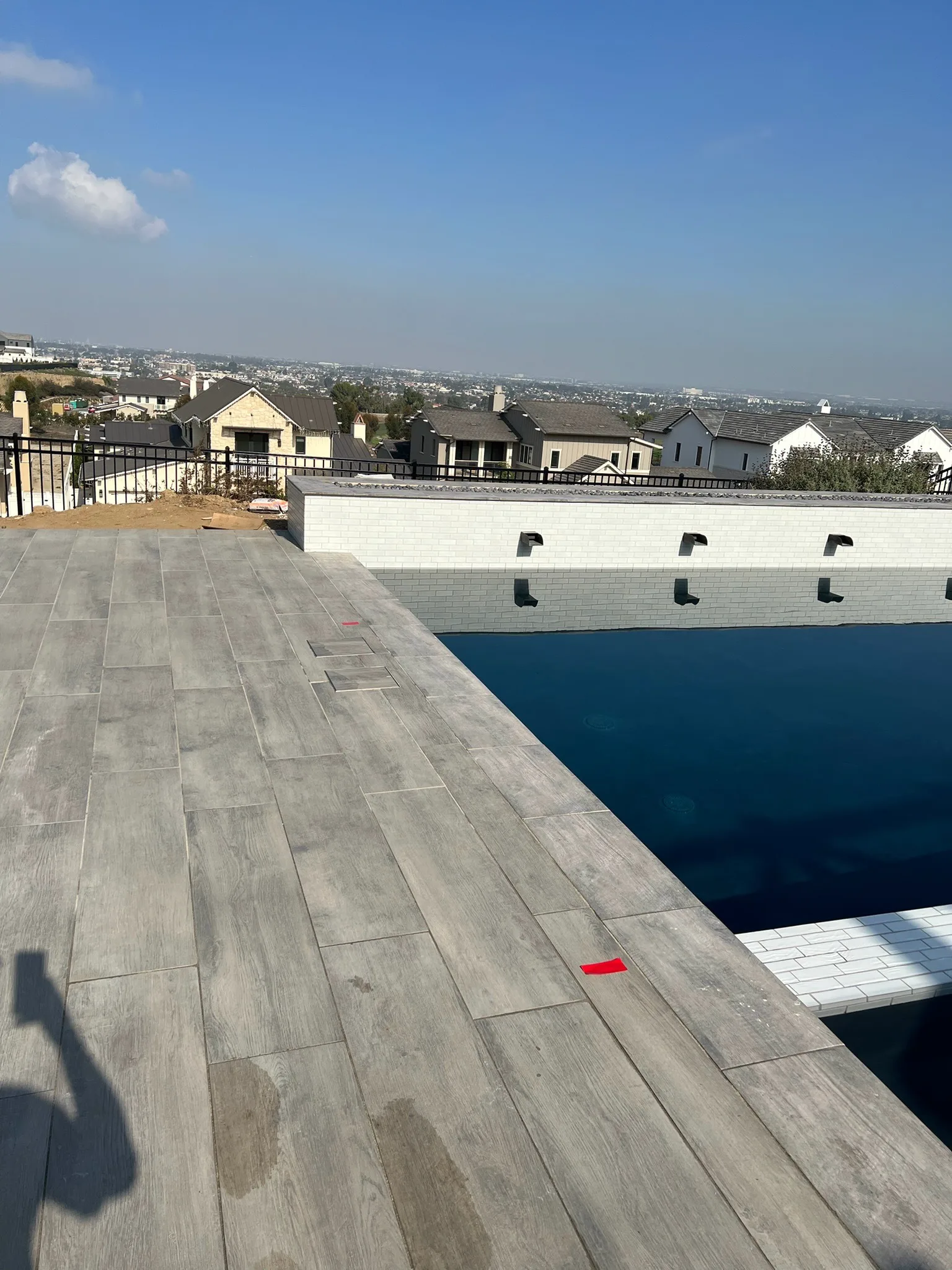 Wood-look porcelain tile deck surrounding a pool