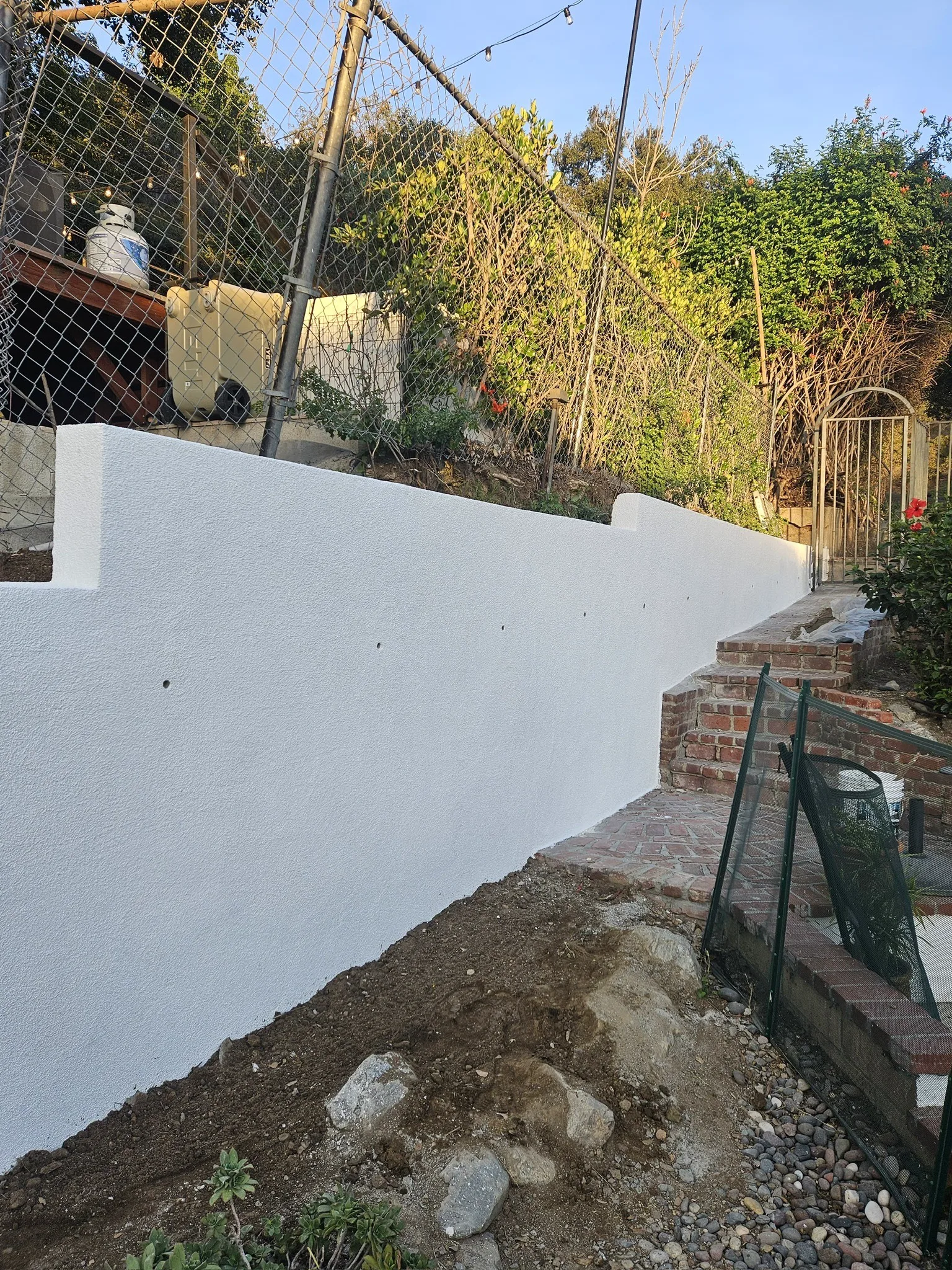 White stucco retaining wall along a property line