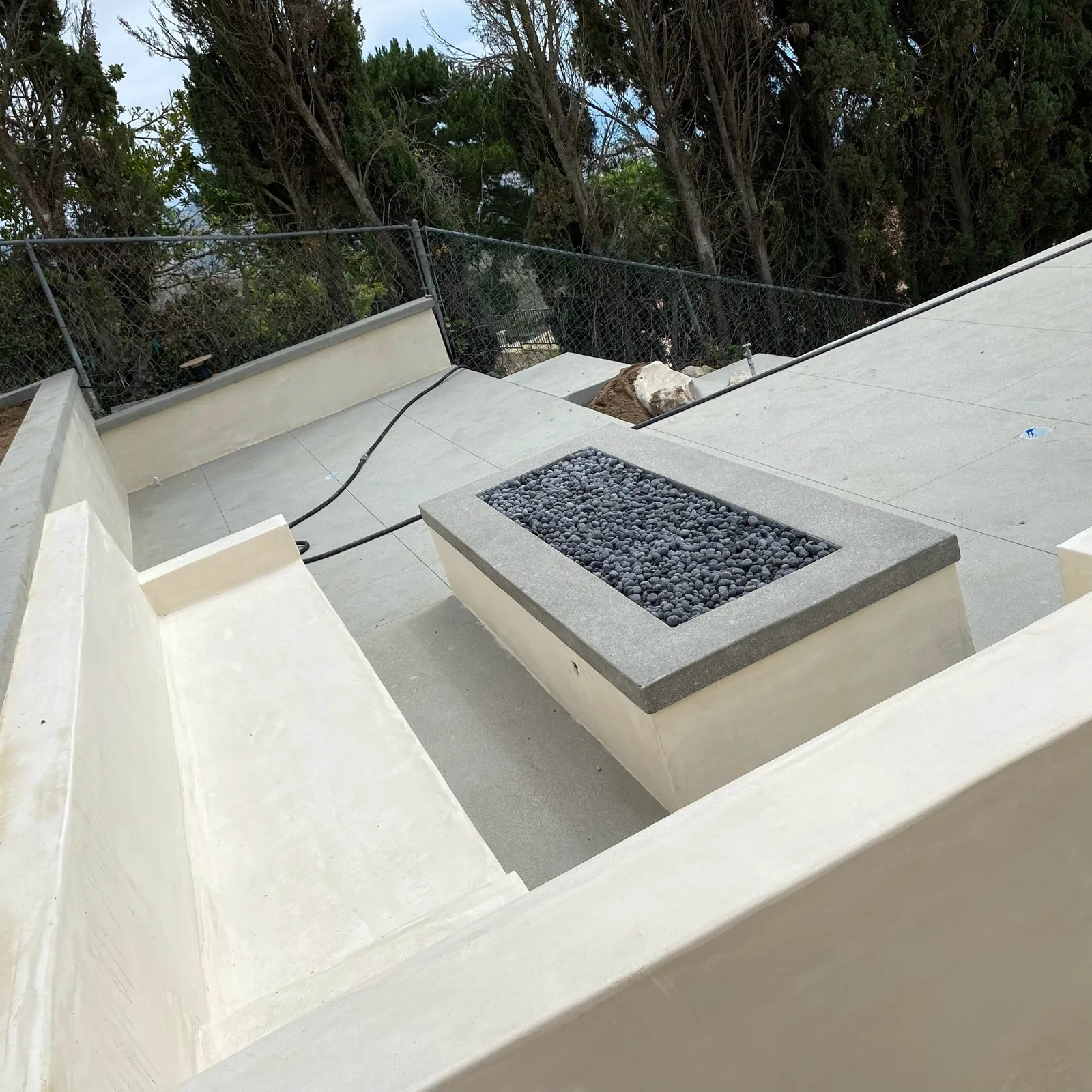 Rooftop fire feature with lava rock and glass railing