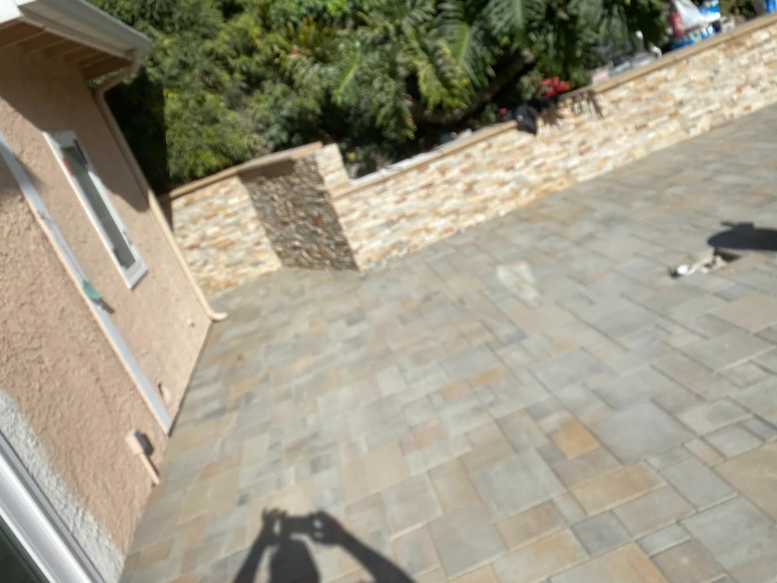 Stone veneer wall beside a paver pool patio at an LA area home